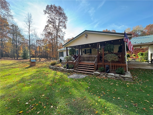 rear view of property featuring covered porch, a yard, and a patio area