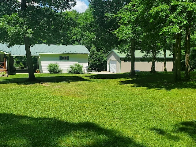 view of yard with a garage and an outbuilding