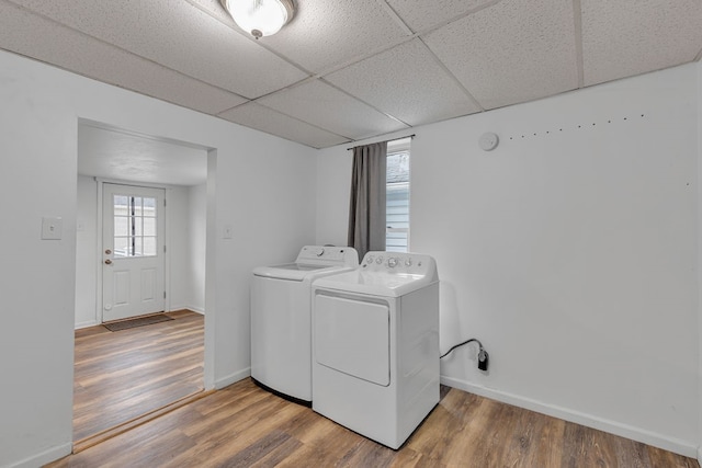 laundry room with washing machine and dryer and hardwood / wood-style flooring