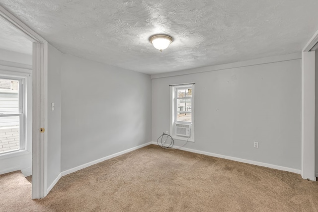 carpeted spare room featuring plenty of natural light and a textured ceiling