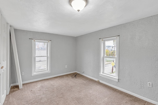 carpeted empty room with a healthy amount of sunlight