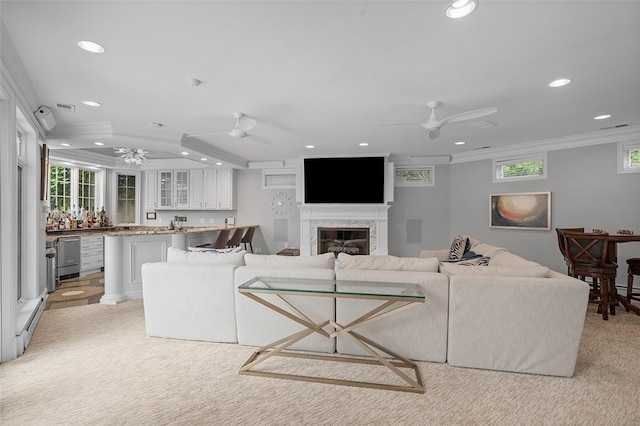 living room with ornamental molding, bar, a premium fireplace, light colored carpet, and ceiling fan