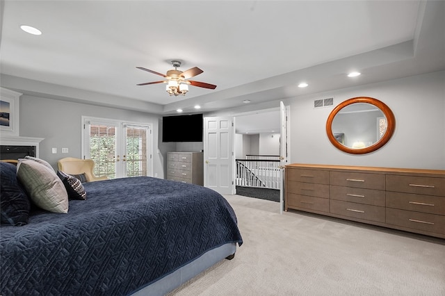 bedroom with access to outside, ceiling fan, a tray ceiling, and light colored carpet