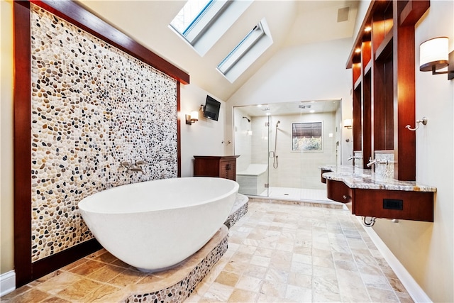 bathroom featuring high vaulted ceiling, shower with separate bathtub, a skylight, and vanity