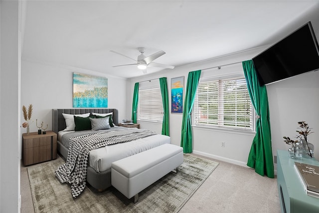 carpeted bedroom featuring ceiling fan and crown molding