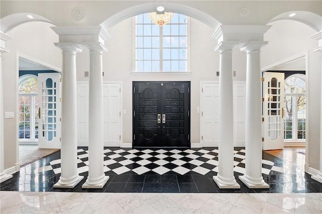 entryway featuring plenty of natural light, a high ceiling, and an inviting chandelier