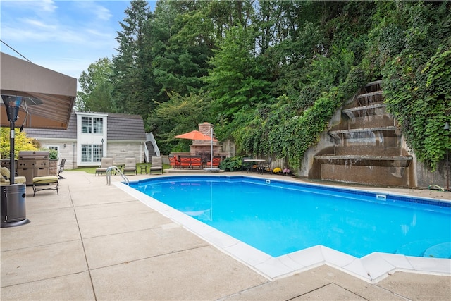 view of pool with a grill and a patio area