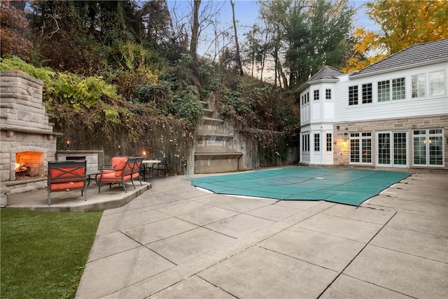 view of pool with a patio area and an outdoor stone fireplace