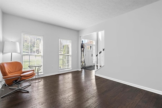 sitting room featuring dark wood-type flooring and a textured ceiling