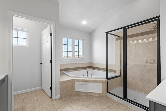 bathroom with tile patterned flooring, vanity, a textured ceiling, and separate shower and tub