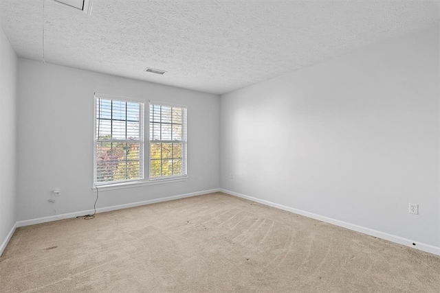 carpeted spare room with a textured ceiling