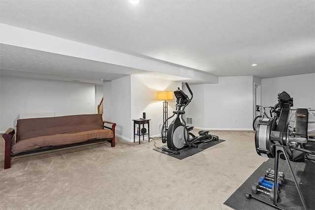 workout room featuring a textured ceiling and carpet flooring