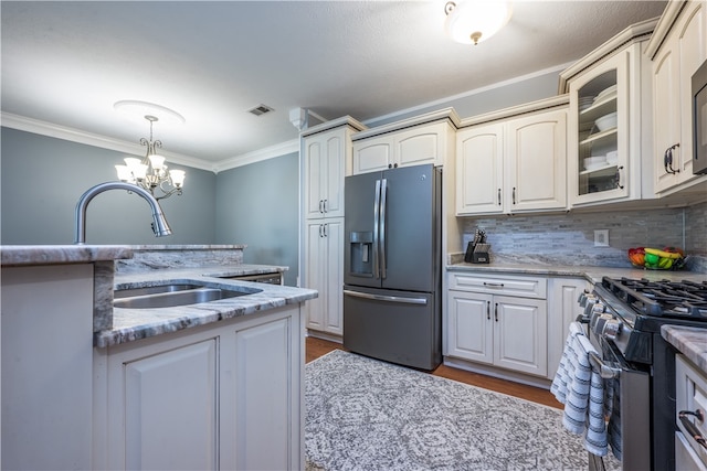 kitchen featuring stainless steel appliances, light hardwood / wood-style floors, sink, tasteful backsplash, and dark stone counters