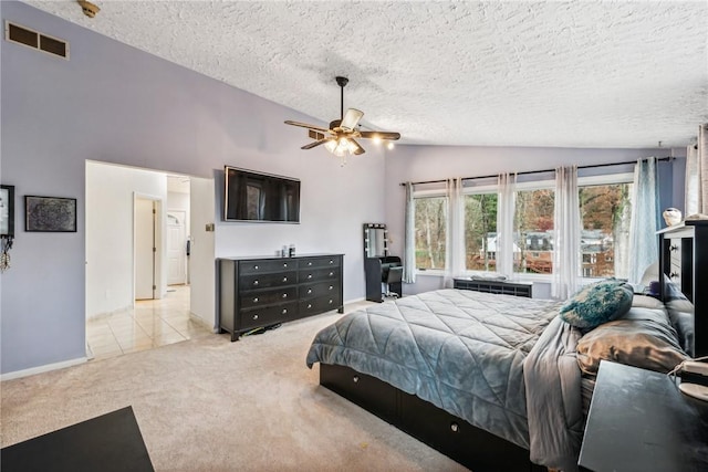 bedroom with vaulted ceiling, light carpet, a textured ceiling, and ceiling fan