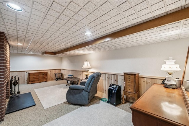 carpeted office with a fireplace and wooden walls