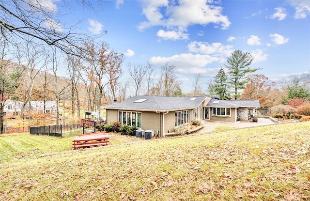 back of house featuring a yard, a patio, and central air condition unit