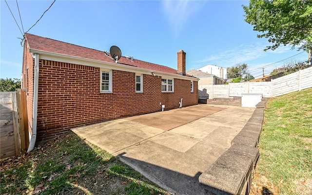 969 Kirsopp Ave, Banksville/Westwood, PA 15220 - rear view of property featuring brick siding, a chimney, a patio, and a fenced backyard