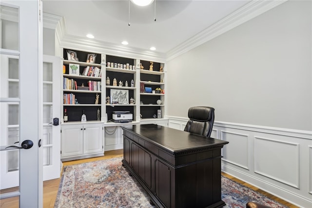 office area with built in features, crown molding, and light hardwood / wood-style flooring