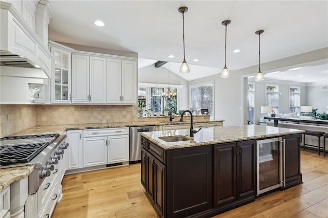 kitchen featuring white cabinets, light hardwood / wood-style floors, beverage cooler, and appliances with stainless steel finishes