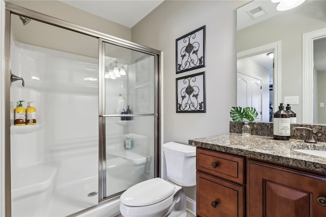 bathroom with vanity, toilet, and an enclosed shower