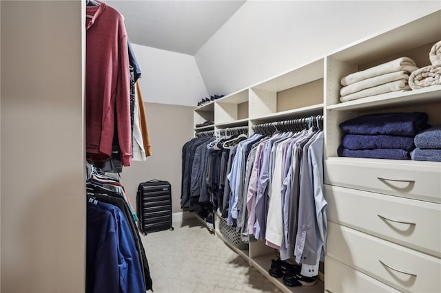 walk in closet featuring light carpet and vaulted ceiling