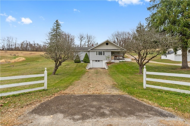 view of front of house with a garage, a rural view, a front lawn, and a porch