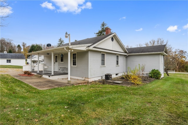 back of property with a lawn, cooling unit, and a patio area