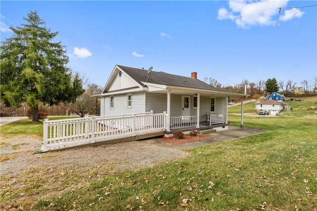 rear view of house with a porch and a lawn