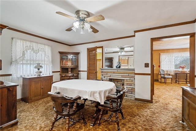 dining room featuring ornamental molding, wooden walls, and light carpet