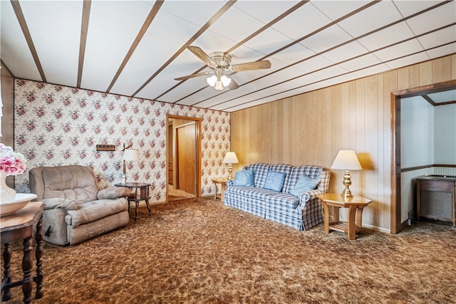 living room with wood walls, ceiling fan, and carpet floors