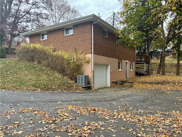 view of home's exterior with central AC unit and a garage