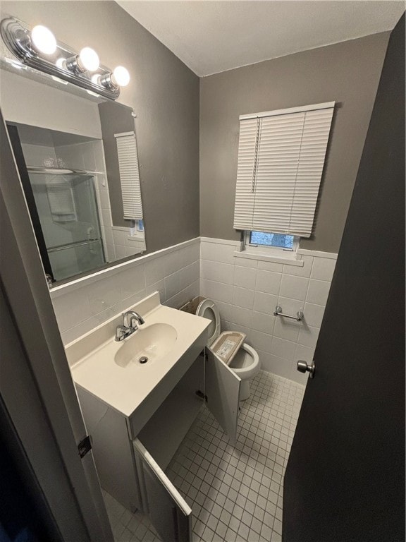 bathroom featuring tile walls, tile patterned floors, vanity, an enclosed shower, and toilet