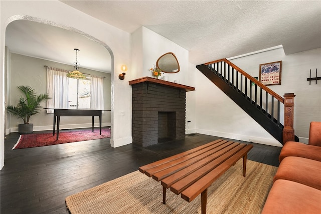 living room featuring a textured ceiling, a fireplace, and hardwood / wood-style flooring