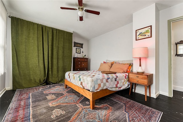 bedroom with dark hardwood / wood-style flooring, vaulted ceiling, and ceiling fan