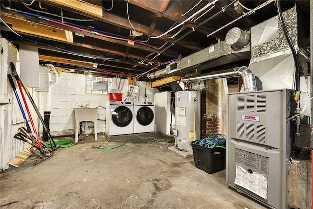 basement featuring washer and dryer, gas water heater, and sink