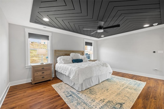 bedroom featuring multiple windows, hardwood / wood-style flooring, ceiling fan, and crown molding