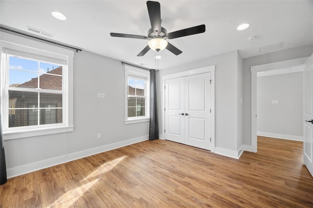 unfurnished bedroom featuring ceiling fan, a closet, and light wood-type flooring