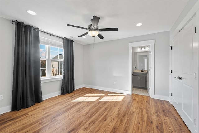 unfurnished bedroom featuring connected bathroom, light hardwood / wood-style floors, and ceiling fan