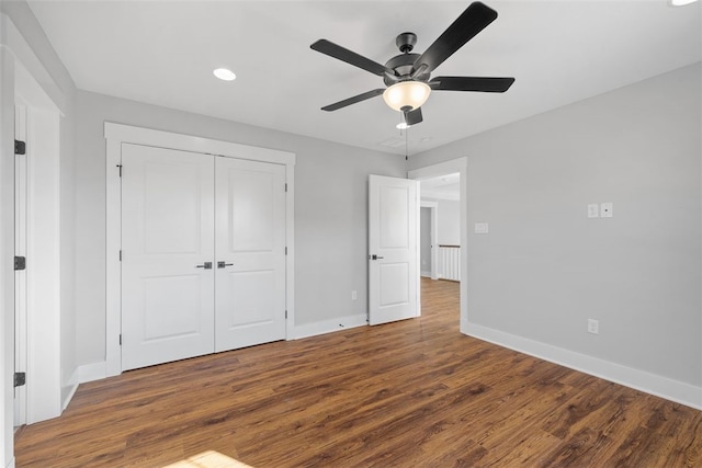 unfurnished bedroom with hardwood / wood-style flooring, ceiling fan, and a closet