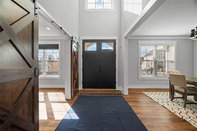 entryway with a barn door and light hardwood / wood-style flooring