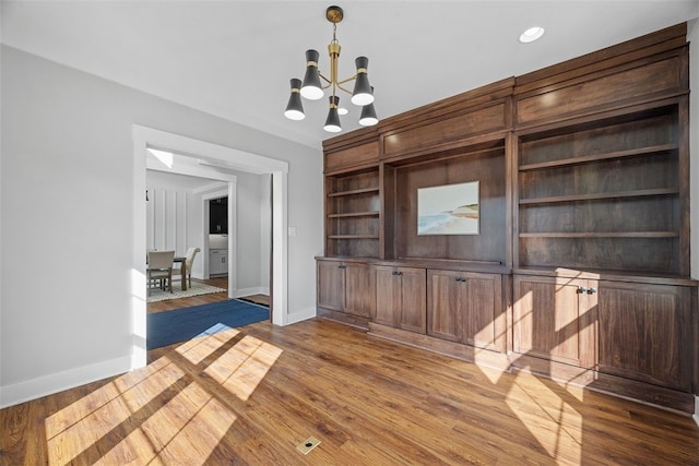 unfurnished living room with dark hardwood / wood-style flooring and a chandelier