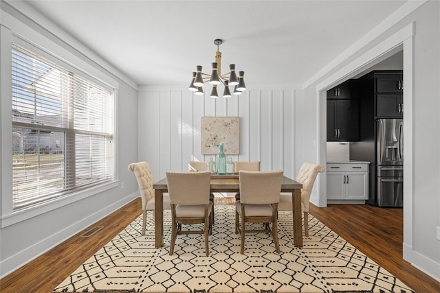 dining room featuring ornamental molding, dark hardwood / wood-style flooring, and an inviting chandelier