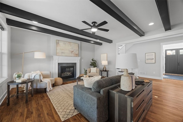 living room featuring hardwood / wood-style floors, beamed ceiling, and ceiling fan