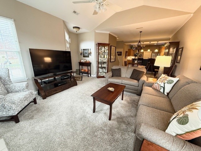 living room featuring carpet, vaulted ceiling, and ceiling fan with notable chandelier