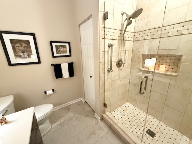 bathroom featuring toilet, vanity, and an enclosed shower