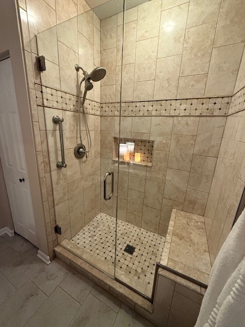 bathroom with an enclosed shower and tile patterned flooring