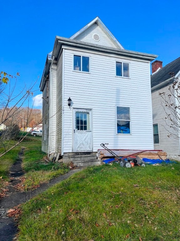 rear view of house featuring a yard