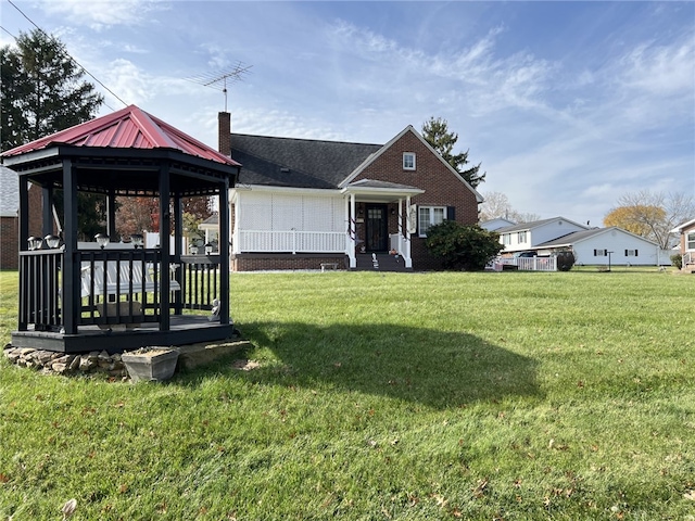 view of front of property featuring a front lawn and a gazebo