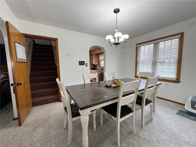 dining room featuring light colored carpet, sink, and a notable chandelier