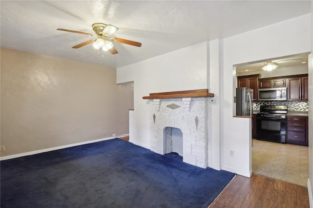 unfurnished living room with wood-type flooring, ceiling fan, and a brick fireplace